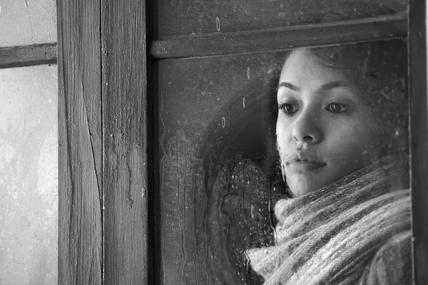 Retrato de uma bela mulher atrás da janela — Fotografia de Stock