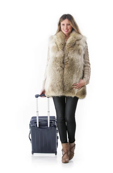 Junge Frau in Winterkleidung mit rollendem Koffer. — Stockfoto