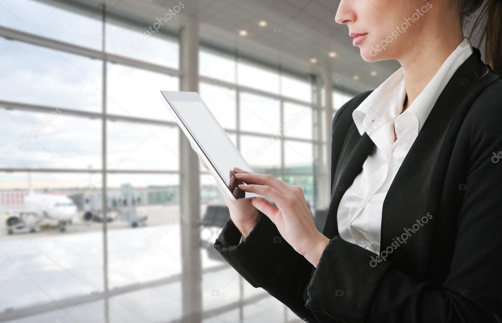 Businesswoman using tablet computer at departure lounge