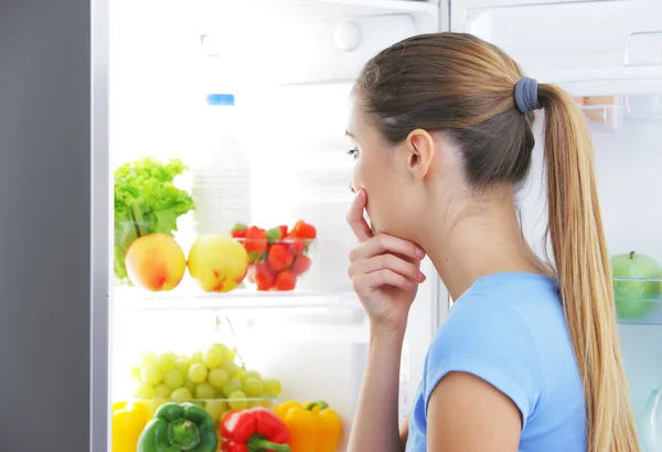 Jovem mulher escolhendo comida — Fotografia de Stock