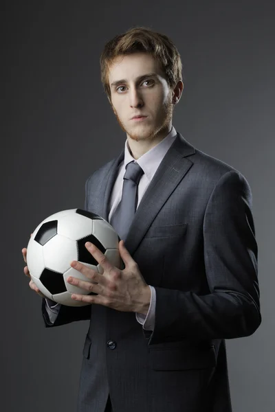 Elegant businessman holding a soccer ball — Stock Photo, Image