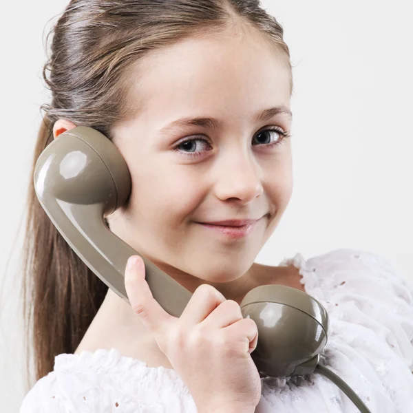 Маленька дівчинка з старовинним телефоном — стокове фото