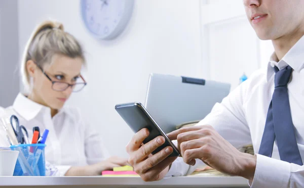 Businessman using smart phone in office — Stock Photo, Image