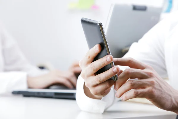 Empresario usando teléfono inteligente en la oficina — Foto de Stock