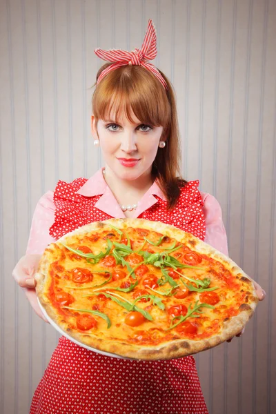Домохозяйка-ретро держит вегетарианскую пиццу — стоковое фото
