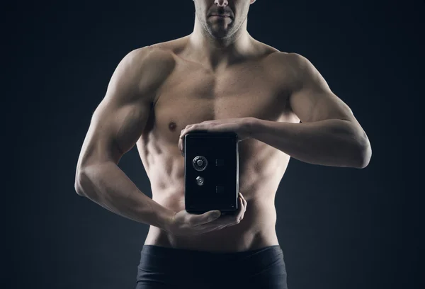 Homme musculaire protège les économies dans le coffre-fort — Photo