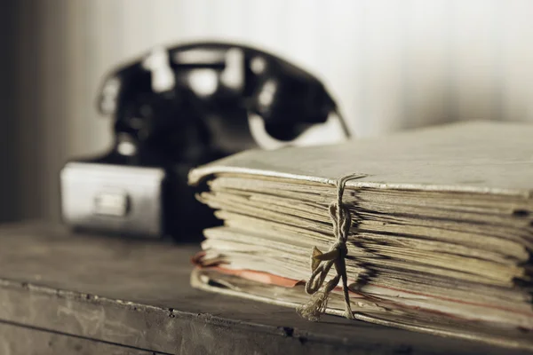 Starý telefon na stole s dokumenty — Stock fotografie