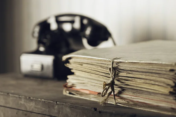 Old phone on a desk with documents