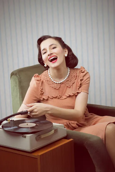 Mujer joven escuchando música desde un tocadiscos — Foto de Stock