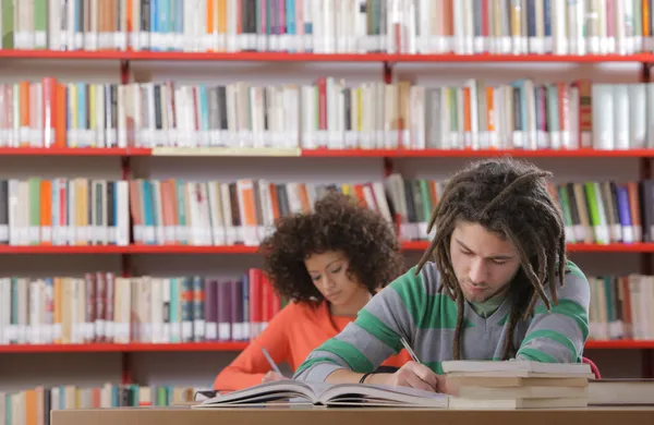Két diák egy könyvtárban. — Stock Fotó