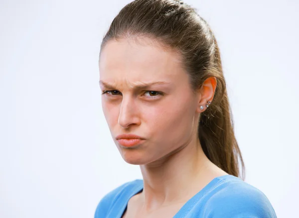 Portrait of a young woman scowling at you — Stock Photo, Image