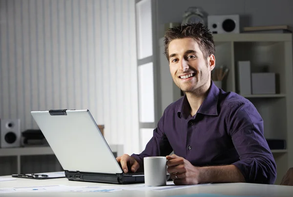 Молодой человек работает на ноутбуке Лицензионные Стоковые Изображения