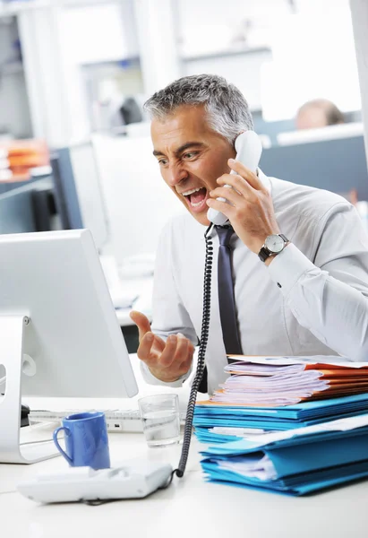 Stressed business man shouting at phone in office — Stock Photo, Image