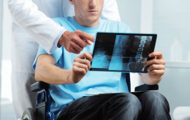Doctor showing X-ray to patient clipart