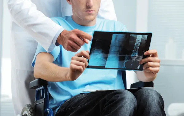 Läkare visar röntgen till patient — Stockfoto