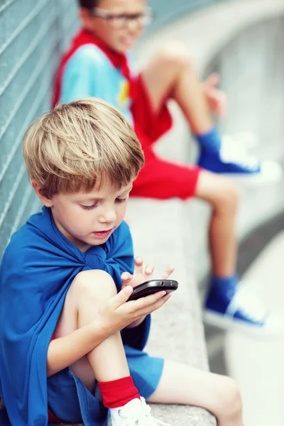 Pequeño superhéroe con smartphone —  Fotos de Stock