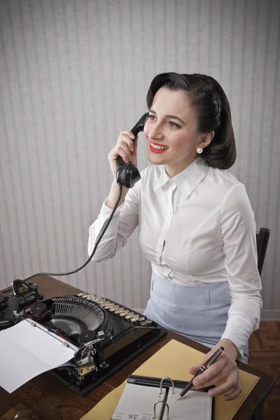 Kvinnan pratar på telefon på skrivbordet — Stockfoto