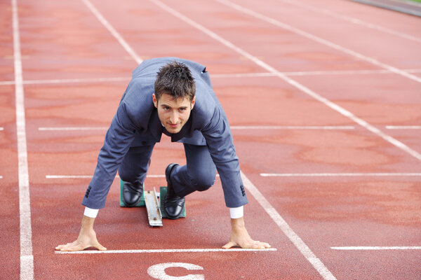 Бизнесмен на треке, готовый бежать
