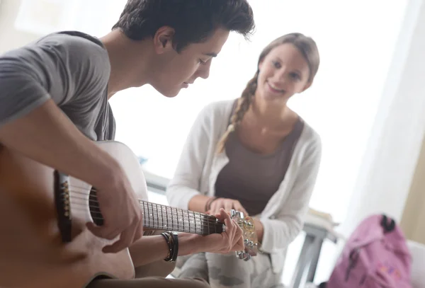 Romantyczny chłopiec gry na gitarze dla jej dziewczyna — Zdjęcie stockowe