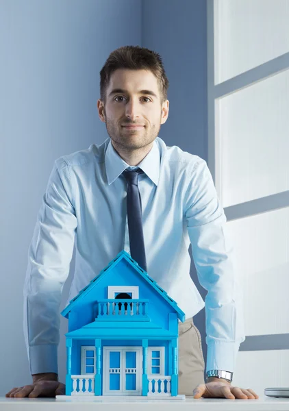 Onroerende goederenagent met model huis — Stockfoto