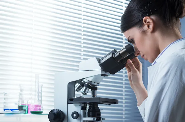 Kvinnliga forskare genom Mikroskop — Stockfoto