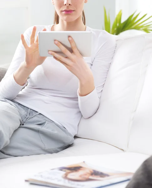 Mulher relaxante no sofá com tablet — Fotografia de Stock