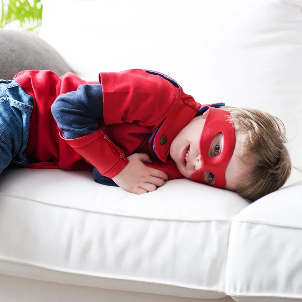 Piccolo supereroe appoggiato sul divano — Foto Stock