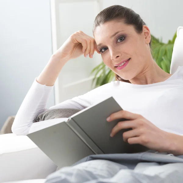 Woman reading on sofa — Stock Photo, Image