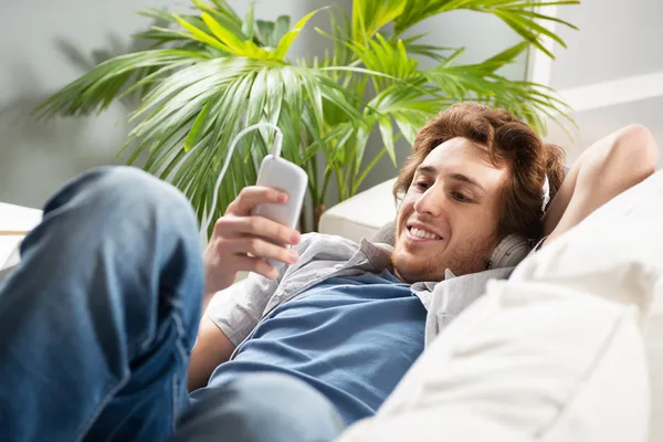 Guy with headphones on sofa — Stock Photo, Image