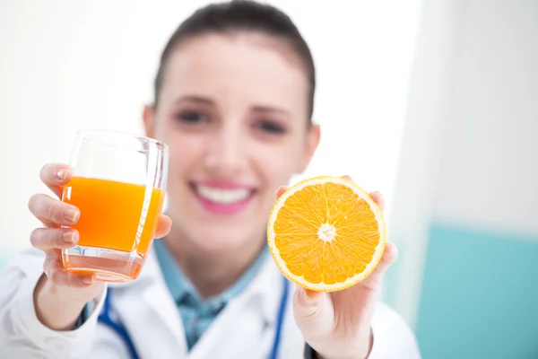 Doctor with glass of orange juice — Stock Photo, Image