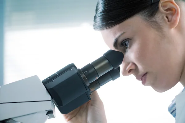 Female researcher using microscope — Stock Photo, Image
