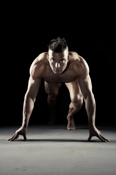 Мускулистый спортсмен готов бежать — стоковое фото