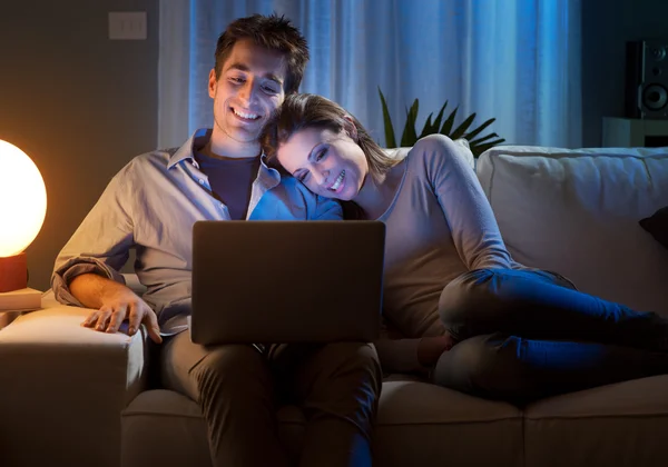 Jeune couple à la maison avec ordinateur portable — Photo