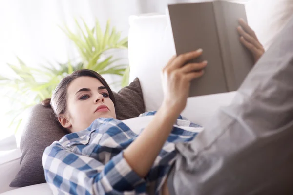 Mulher leitura livro no sofá — Fotografia de Stock