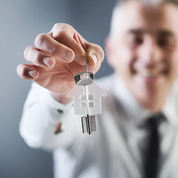 Agente inmobiliario sosteniendo las llaves de la casa — Foto de Stock