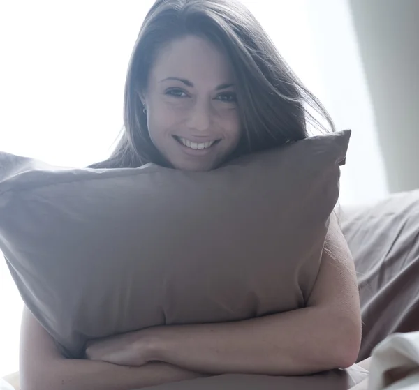 Vrouw omarmen haar kussen — Stockfoto