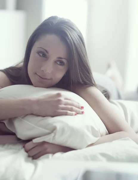 Uma jovem mulher linda deitada na cama — Fotografia de Stock