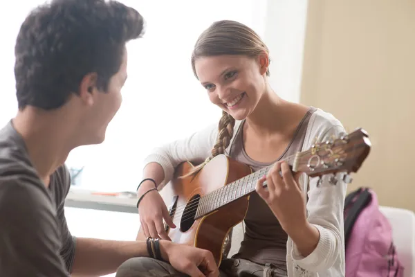 Flicka spela gitarr för sin pojkvän — Stockfoto