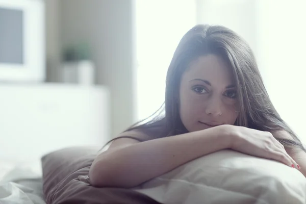 Mujer joven acostada en la cama — Foto de Stock