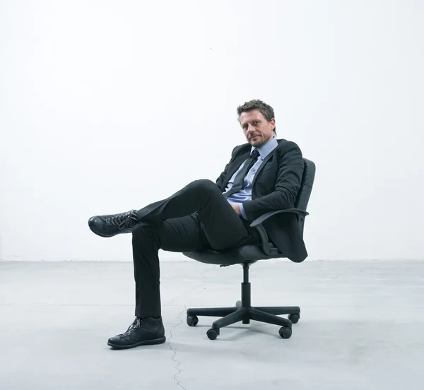 Elegante hombre de negocios sentado en una silla de oficina — Foto de Stock