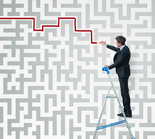 Elegant affärsman på en stege lösa en labyrint med en pensel. — Stockfoto