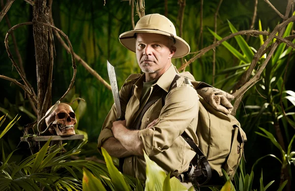 Aventureiro com equipamento de sobrevivência estilo colonial na selva com crânio . — Fotografia de Stock