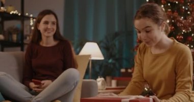 Kız kardeşinden Noel hediyesi alıyor.