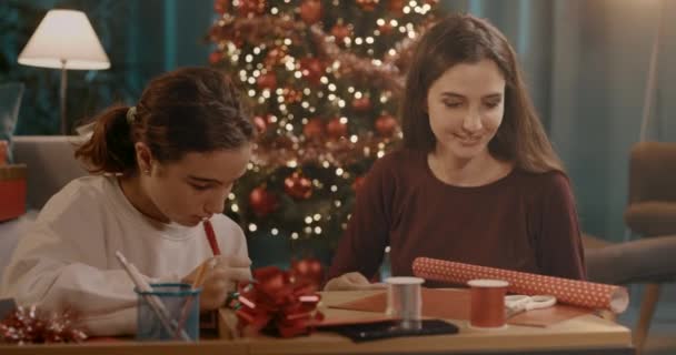 बहिणी एकत्र ख्रिसमस भेटवस्तू तयार करतात — स्टॉक व्हिडिओ