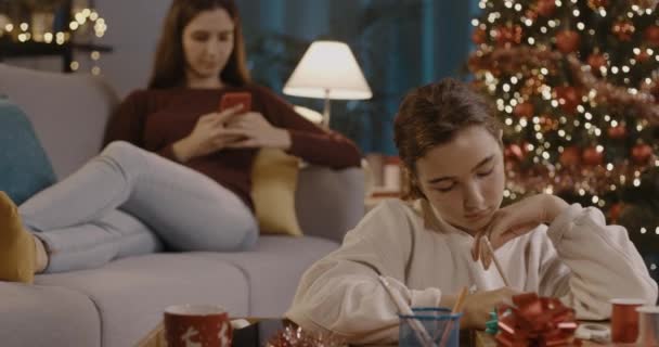 Милая девушка пишет рождественскую открытку дома — стоковое видео