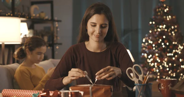 Woman Preparing Christmas Gifts Home Her Sister Sitting Background — Stock Photo, Image