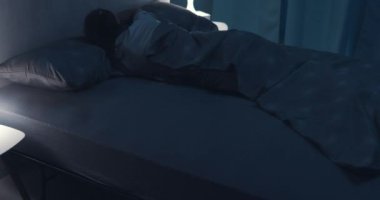 Yatağında uykusuzluk çeken bir kadın.