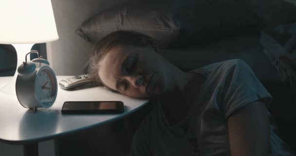 Женщина лежит головой на тумбочке и спит. — стоковое видео