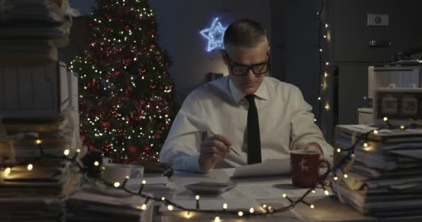 Sad businessman working on Christmas day — Stock Video