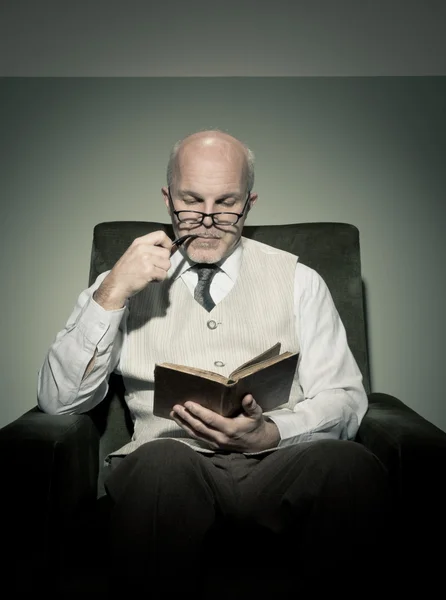 Profesor leyendo en sillón —  Fotos de Stock